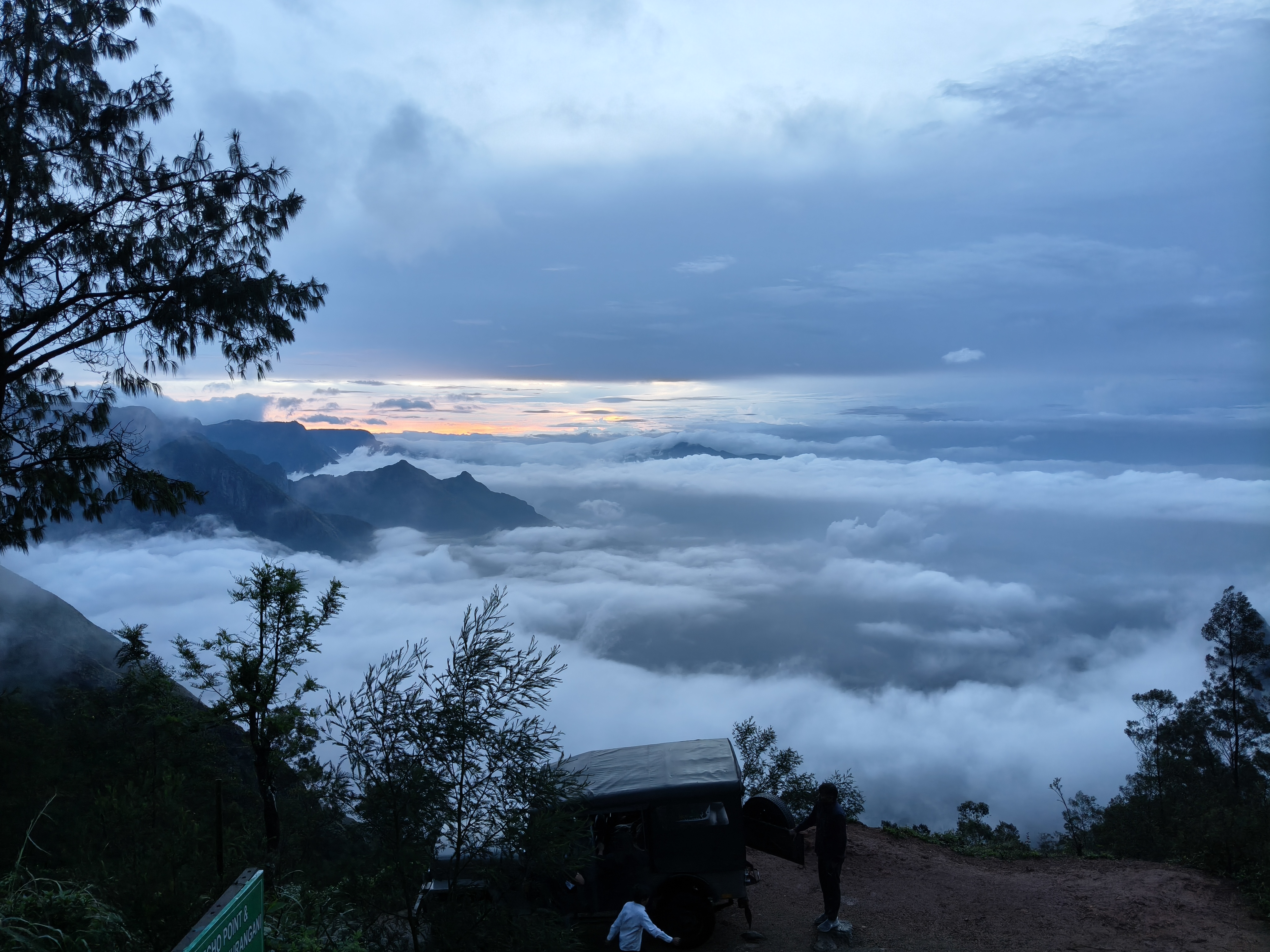 Kolukkumalai sunrise with glowing orange sky and misty mountains